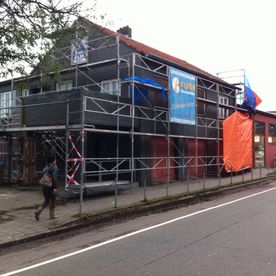 Bij zandstralen spuit Fijten Gevelverzorging een mengsel van water en zand onder hoge druk op de muur.